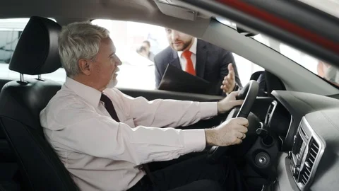 Test drive. Client at the steering wheel. The sales man is outside. Client Stock Footage 91187215