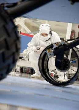 A test operator in clean-room garb observes rolling of the wheels during th.. Stock Photos