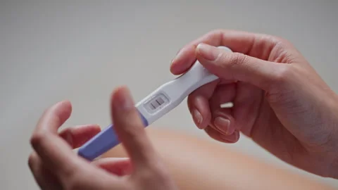 Test results, Single parent Slowly Checking a pregnancy test In the women's Stock Footage 242539958