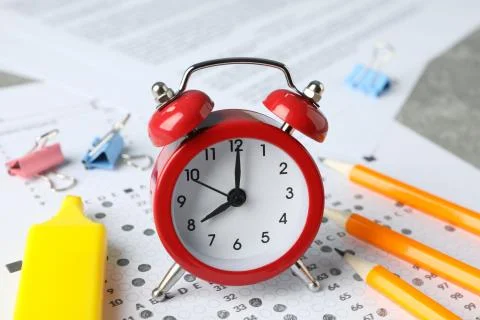 Test score sheet, alarm clock and stationery, close up Stock Photos