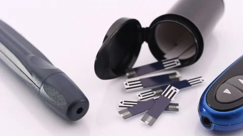 Test Strips, Glucose Meter and a Lancing Device Lying on a White Shiny Table Pan Video stock 56479265