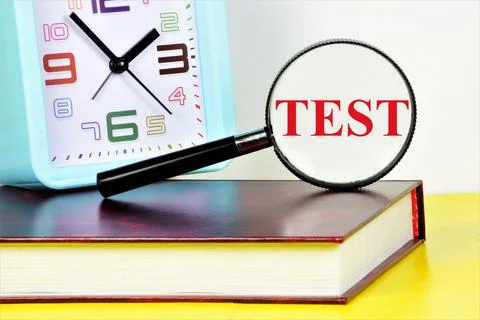 Test. Text inscription on the background of the clock and the textbook. Stock-Fotos