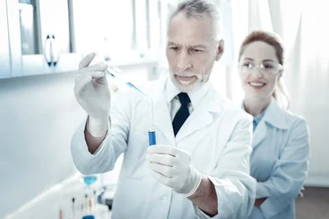 Test tube being held by a smart professional scientist Stock Photos