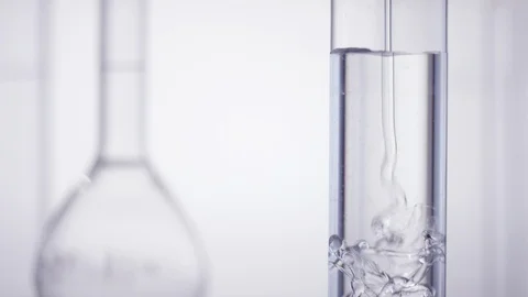 Test tube get filled with viscous liqud inf front of white background Stock Footage 100558587