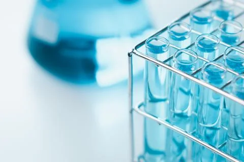 Test tubes and erlenmeyer flask filled with blue sample chemicals in chemis.. Stock Photos