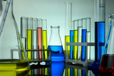 Test tubes and flasks with colored liquids stand on a table in a laboratory Stock Photos