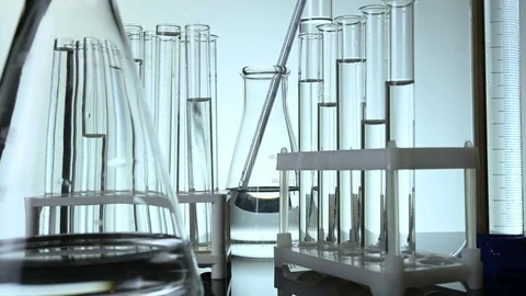 Test tubes and flasks stand with clear liquids on a table in a laboratory Stock Footage 121635338