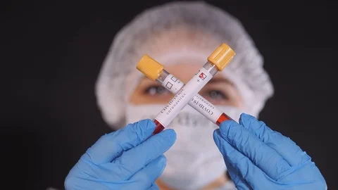 The test tubes are crossed in the doctor's hands. Girl examines a test tube with Stock Footage 128921694