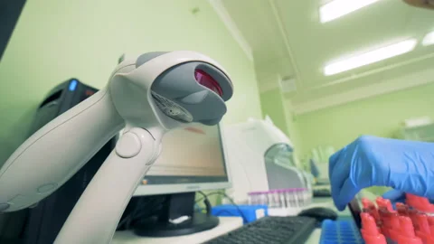 Test tubes are getting scanned by a bar code reader, bar code scanner. Stock Footage 93736379