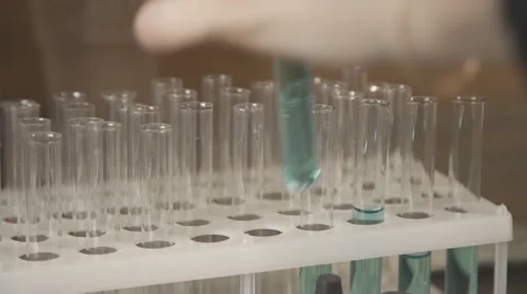 Test tubes with colored liquid chemical in a plastic tripod stand Stock Footage 63997543