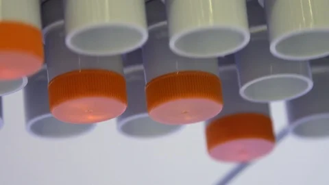 Test tubes containing coloured liquid is turned by a machine in a laboratory Stock Footage 126717858