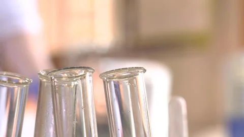 Test Tubes in Foreground with Blurred Busy Laboratory Background Stock Footage 296846036