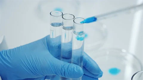 Test tubes in the hands of a scientist. Drop of blue reagent. Stockbeeldmateriaal 142692901