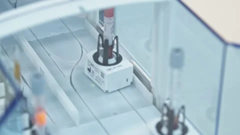 Test tubes in holders moving one after another in a line. Lab concept. Close Stock Footage 232687065