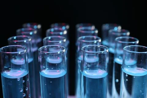 Test tubes with liquid on black background, closeup. Laboratory analysis Foto stock