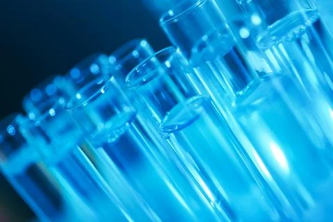 Test tubes with liquid on blue background, closeup. Solution chemistry Stock Photos