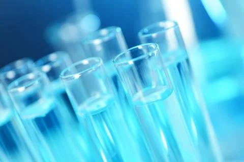 Test tubes with liquid on blue background, closeup. Solution chemistry Stock Photos