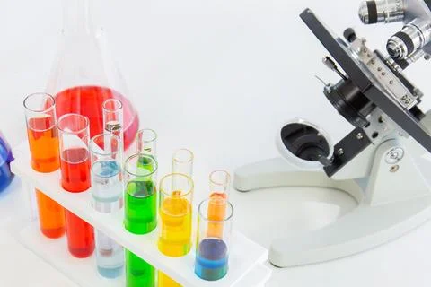 Test tubes in a stand and a microscope on a white table Stock-Fotos