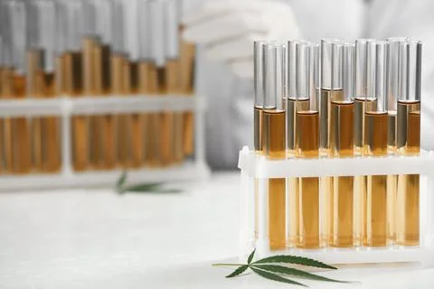 Test tubes with urine samples, hemp leaf and blurred doctor on background Stock Photos