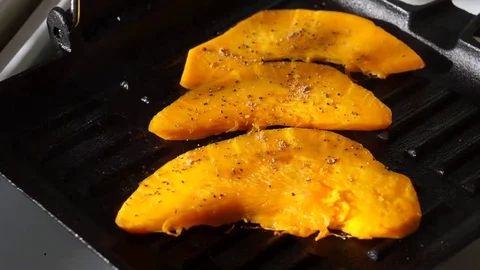 A test of the willingness of the pieces of pumpkin with a fork on the grill pan Stock Footage 72725878