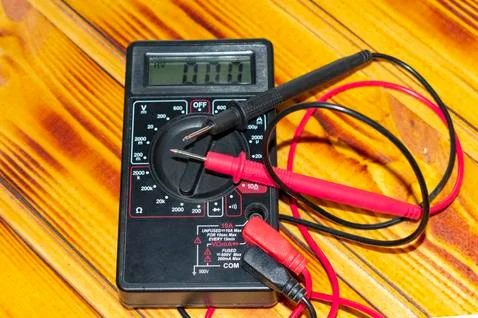 Tester, multimeter, electrical measuring device. on a dark wood background. Stock Photos