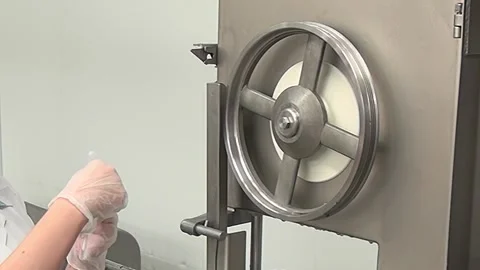 Testing Blade Sharpness on a Meat Cutting Band Saw in the Factory Stock Footage 320138511