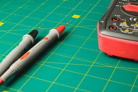 Testing electrical circuits with multimeter and probes on green work surface Stock Photos