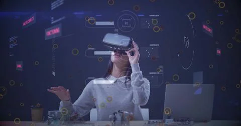 Testing engineer wearing VR headset at lab desk, with laptop, coffee cup, 写真素材