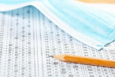 Testing in exercise and examination work. blue medical mask, sheet with penci Stock Photos