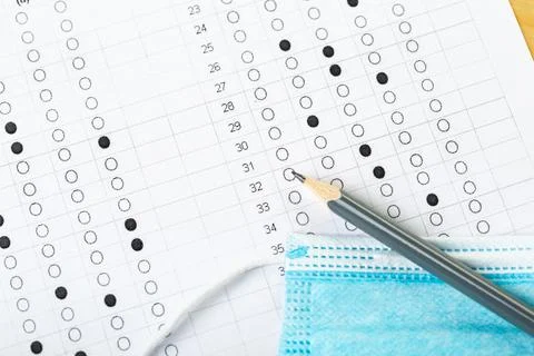 Testing in exercise and examination work. blue medical mask, sheet with penci Stock Photos