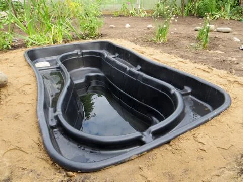 Testing of an installed preformed plastic pond insert filled with some wate.. Foto stock