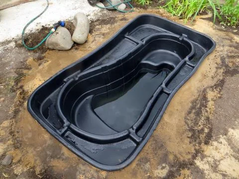 Testing of an installed preformed plastic pond insert filled with some wate.. Stock Photos