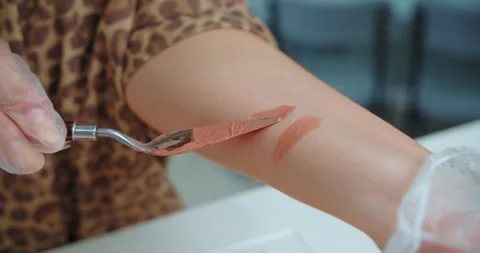 Testing lipstick color with spatula on forearm Stock Footage 314616531