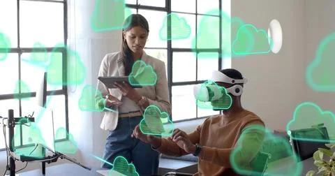 Testing man wearing white VR headset and blazer-clad woman with tablet moving Stock Photos