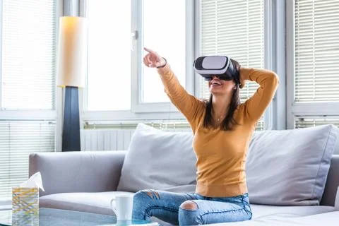 Testing new technologies. Attractive young woman in VR headset gesturing and  Stock Photos