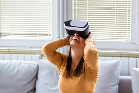 Testing new technologies. Attractive young woman in VR headset gesturing and  Stock Photos