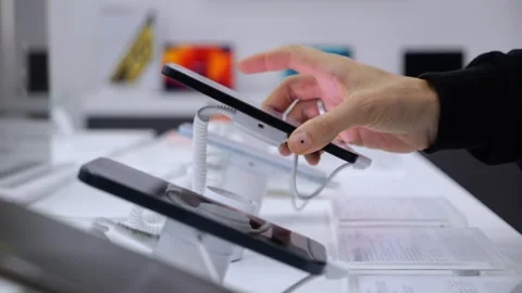 Testing phones in store. Close-up: hand picking up phone and checking it Stock Footage 270005151