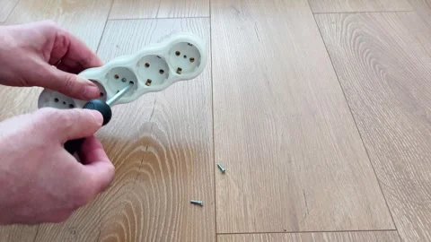 Testing a Power Strip Safety by Dropping Screw on Wooden Floor Surface Video stock 328476579