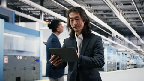 Testing silicon wafer batches, tablet and senior manager in microchip factory Stock Footage 333394893