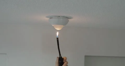 Testing Smoke Detector with Lighter Flame Indoors Stock Footage 331121891