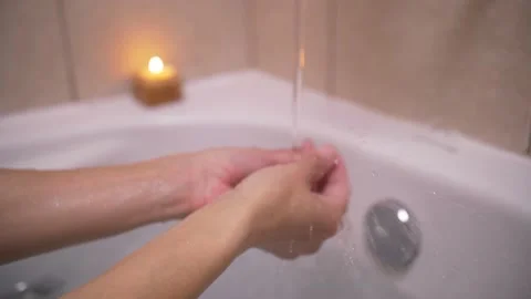 Testing the Water Temperature with Hands Stock Footage 139422597