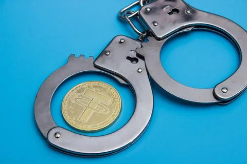 Tether coin and handcuffs Stock Photos