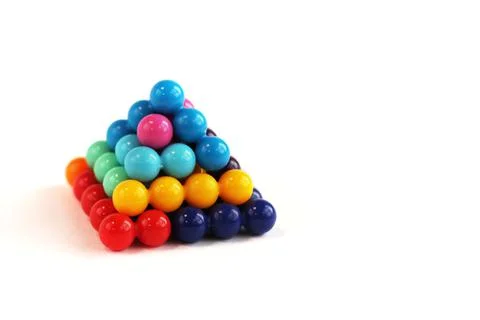 Tetragonal pyramid of multi-colored puzzle elements in the form of balls Stock Photos