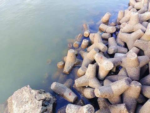 Tetrapods, as a tool for breaking waves on the coast. Stock Photos