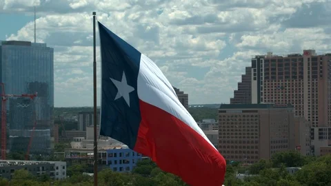 Texas Flag, aerial camera orbits left with downtown Austin in the back, 4K 스톡 동영상 111067822