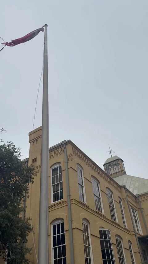 Texas Flag Flying Above Historic Brick Building Stock Footage 344596567