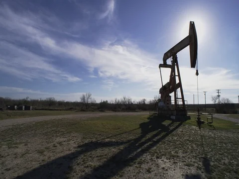 Texas oil rig shadow working continuously Stock Footage
