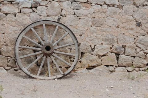 Texas wagon wheel against adobe wall Stock Photos