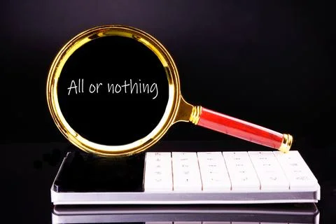 Text ALL OR NOTHING through a magnifying glass on a black background in white Stock Photos