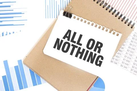 Text ALL OR NOTHING on white paper sheet and brown paper notepad on the tab.. Foto stock